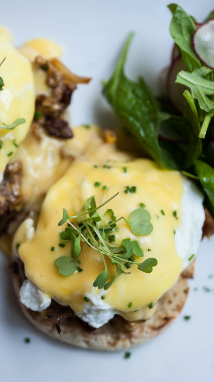Overhead view of Dime Store’s signature Cheesesteak Eggs Benedict topped with hollandaise and chives
