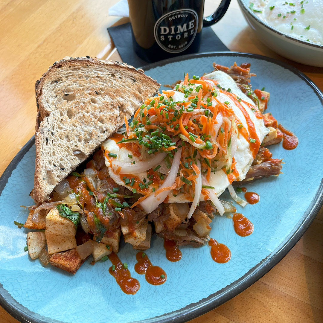 Duck Bop Hash from Dime Store Detroit – house-confit duck leg, Korean BBQ sauce, breakfast potatoes, over easy eggs, and pickled veggies